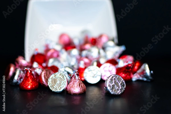 Fototapeta A close up of a white square bowl tipped over spilling candy.