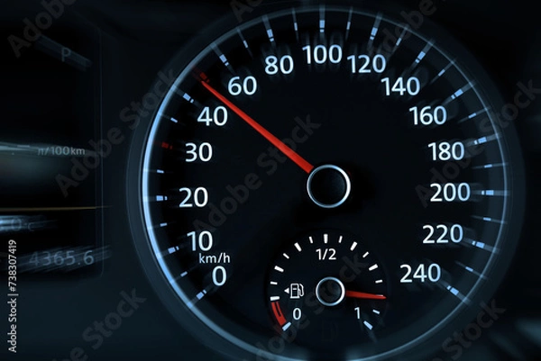 Obraz Speedometer on car dashboard, closeup. Motion blur effect