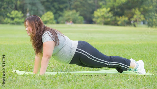 Obraz obese women push ups on grass