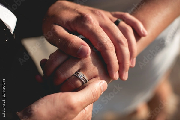 Fototapeta A wedding ring is a finger ring typically worn on the base of the left ring finger, indicates that its wearer is married, usually forged from metal, traditionally gold or another precious metal
