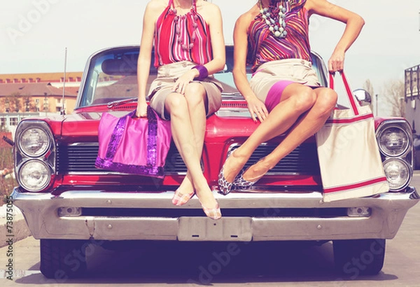 Fototapeta Beautiful ladies legs posing in a vintage retro car