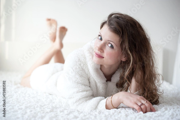 Fototapeta young woman sleeping on the white linen in bed at home, top view