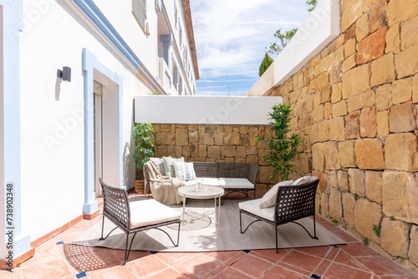 Obraz an image of garden furniture surrounded by stoned wall patio in luxury mediterranean villa 