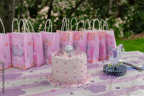 Fototapeta Beautiful cake with pink decor mastic for the birthday of a little girl. Candy bar. Baby shower. Gender Party theme with elephant. Festive background decoration with cake and hearts.