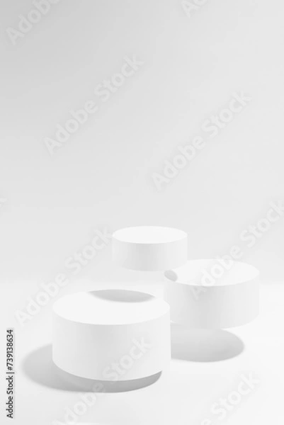 Fototapeta Three white round podiums soar in hard light, set, mockup on white background. Template for presentation cosmetic products, gifts, goods, advertising, design, display, showing in black friday style.