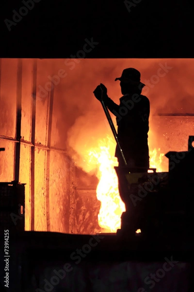 Obraz Man is working in the splashing molten iron - Stock Image