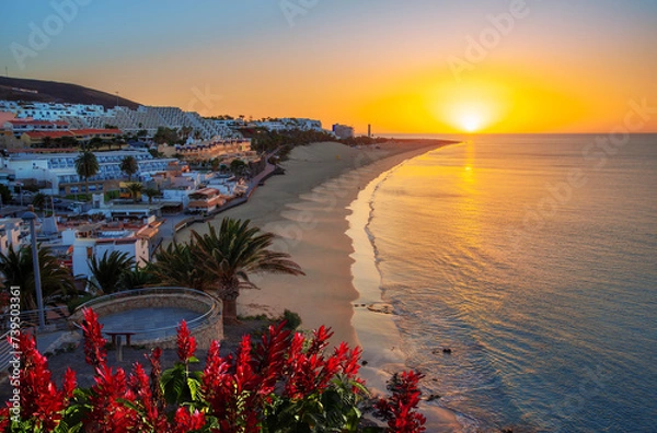 Fototapeta Beautiful sunrise on the coast of the Atlantic Ocean in the region of Jandia with the sun rising over Morro Jable beach on the island of Fuerteventura in Spain