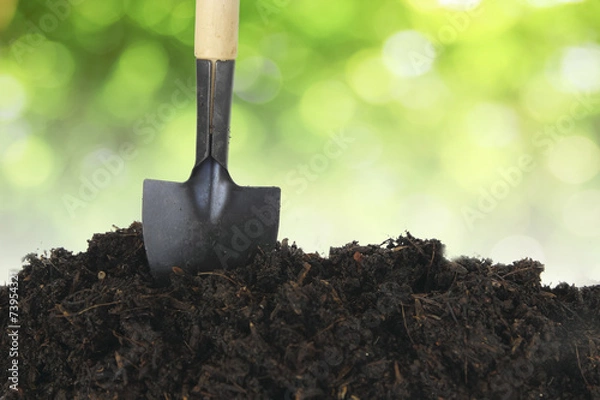 Fototapeta Soil with shovel and green bokeh
