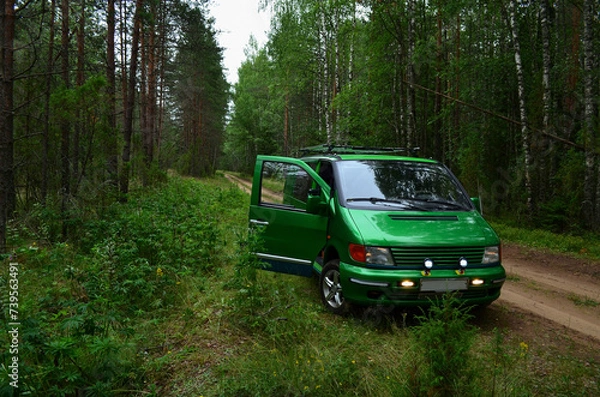 Obraz A green car on a forest road