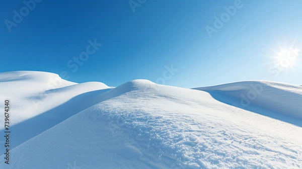 Obraz Pristine snow-covered hills with a clear blue sky and radiant sun, ideal for winter backgrounds or seasonal concept designs, with ample copy space