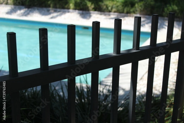 Fototapeta A private swimming pool behind a safety fence. 