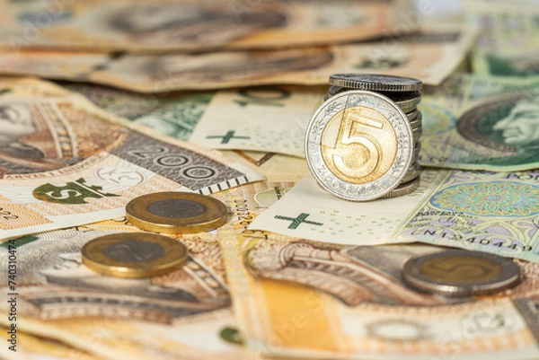 Fototapeta Polish zloty banknotes and coins background. Money background made of polish 100 and 200 zloty banknotes with stacks of coins. 