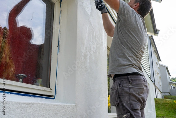 Obraz Man Begins Applying Cement Based Putty: Wall Renovation in Progress.