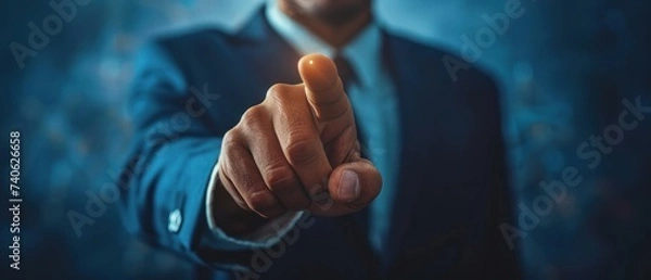 Obraz A professional businessman in a suit pointing forward, engaging with a holographic interface, symbolizing future technology.