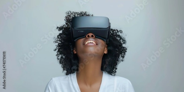 Fototapeta Young woman immersed in virtual reality experience wearing VR headset modern depiction of futuristic technology and networked entertainment showcasing joy and innovation of digital simulation