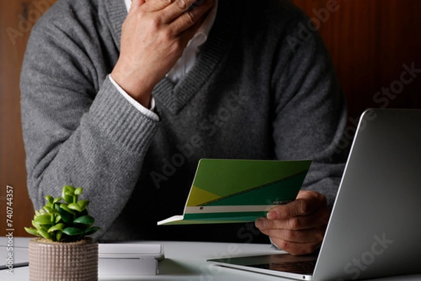 Obraz 通帳残高を確認する男性
