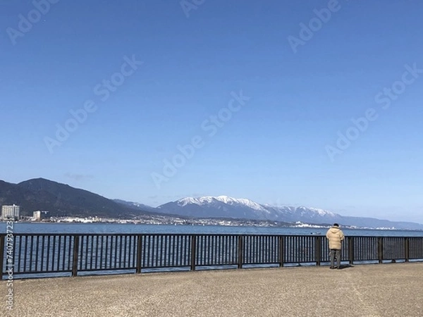 Obraz 冬の海沿いから見る遠景の街の奥に見える山