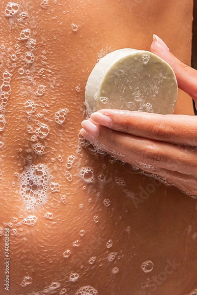 Obraz woman washing body with solid soap
