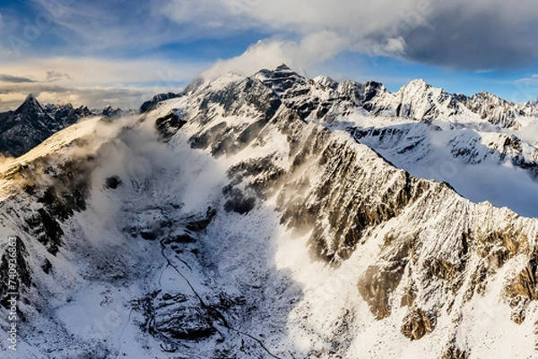 Fototapeta Bird's eye view from drone of snow mountain ridge and peak with cloud at sunset time at Dafeng base camp on the Siguniang Shan mountain in Changping Gou National Parks ,Rilong,Chengdu, China
