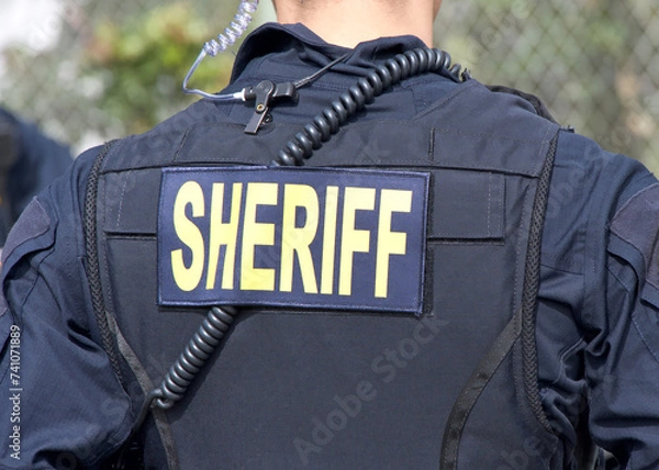 Fototapeta Close up on Sheriff title logo on back of flack jacket.