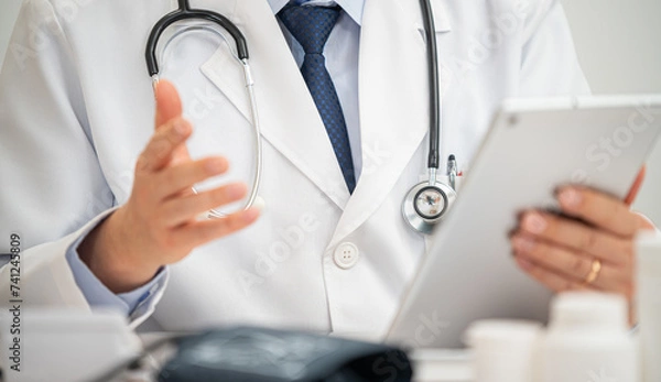 Obraz 비대면진료를 하고있는 중년의 아시아인 의사