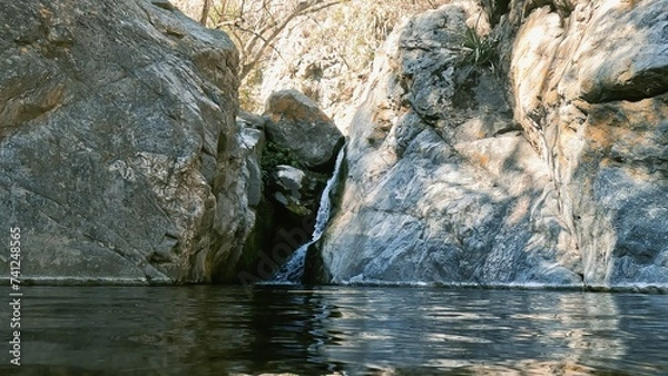 Fototapeta River with rocks and a waterfall in the mountains