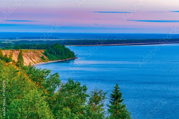 Obraz Seascape - the shore of Lake Onega in selective focus against the background of clouds at sunset.Karelian landscape.Nature, ecology, ecotourism.Forest lake.