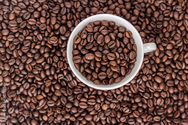 Fototapeta Cup with coffee beans on background of coffee bean, top view