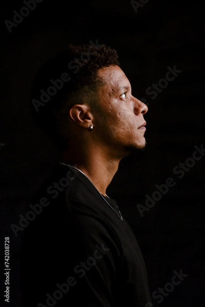 Obraz Low key portrait of young African man in serious profile looking up