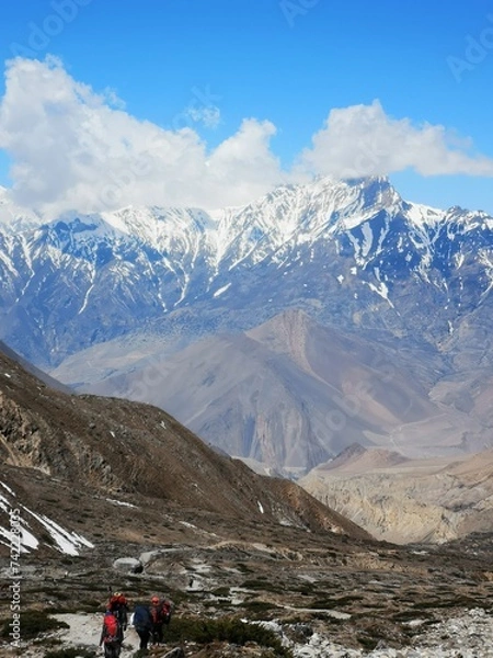 Fototapeta A group of adventurous individuals ascend a towering mountain