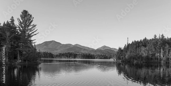 Fototapeta Kayaking in Boreas Ponds in the Adirondacks on a glassy lake with Mount Marcy and the high peaks in the background as the sun is setting.
