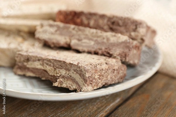 Fototapeta Two kinds of sunflower halva on plate, on wooden background