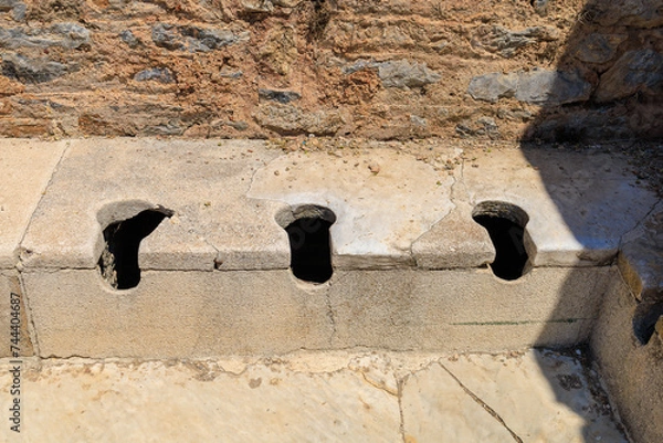 Fototapeta Antique Roman public toilet in the city of Ephesus. Background with selective focus and copy space