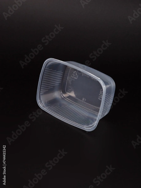 Fototapeta Empty plastic disposable food container, transparent lid isolated on black background.