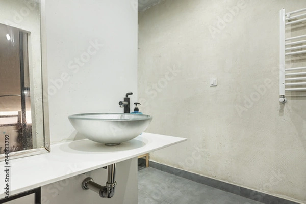 Fototapeta White countertop of a small bathroom with a silver-colored semicircular sink