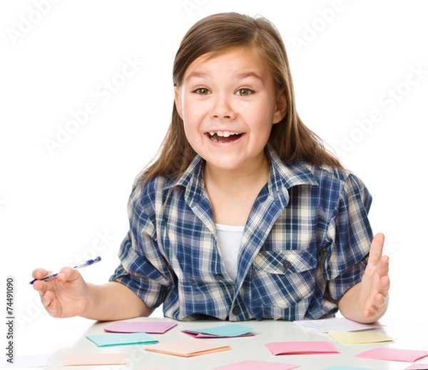 Obraz Girl is writing on color stickers using pen