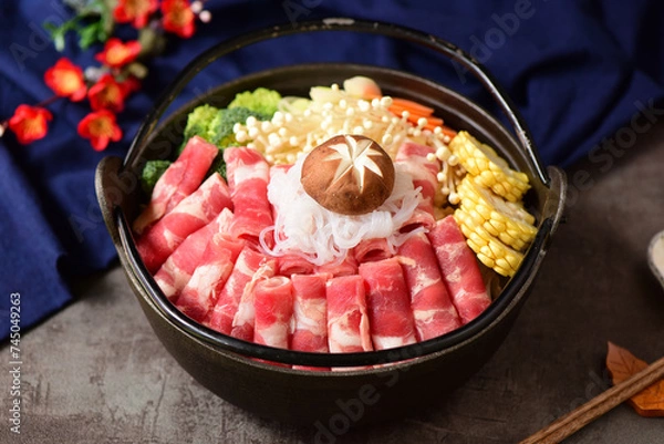 Obraz Fat beef rolls and vegetable ingredients placed in black hot pot