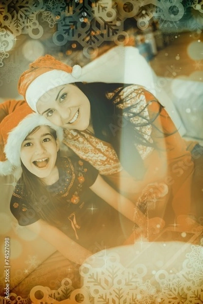 Obraz Composite image of festive mother and daughter using tablet pc