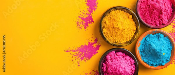 Fototapeta Holi festival background with colorful powder in bowls, wide yellow banner with copy space