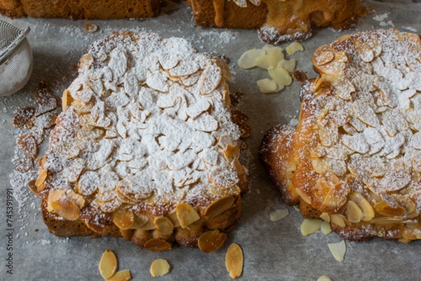 Fototapeta Sweet bread cut into slices and spread with a thin fruit glaze and topped with an almond spread