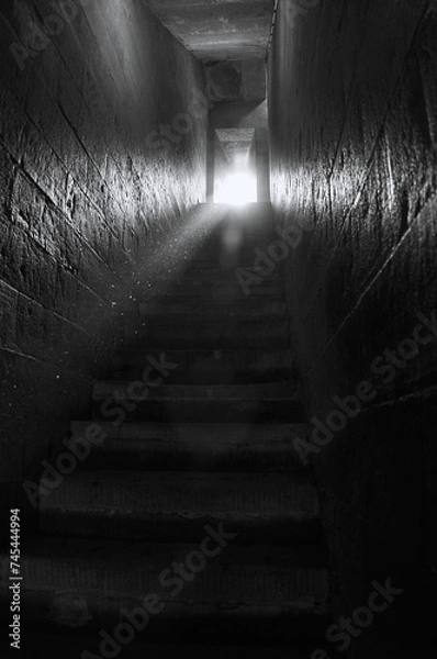 Fototapeta Ancient, narrow, steep stairs bask in a radiant beam of sunlight, creating a mesmerizing scene