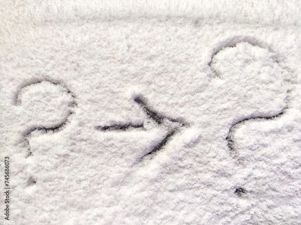 Fototapeta Two question marks and arrow written in the snow. The cold frosty texture of the snow and the question mark. Background, place for text, copy space