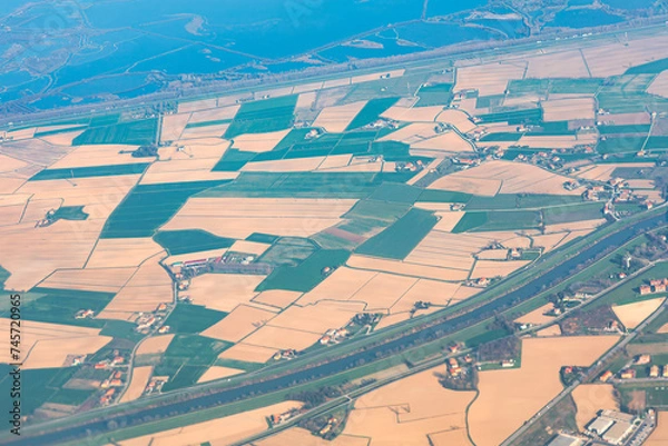 Fototapeta Aerial view of agricultural fields and farmlands. Shot in flight over the countryside.