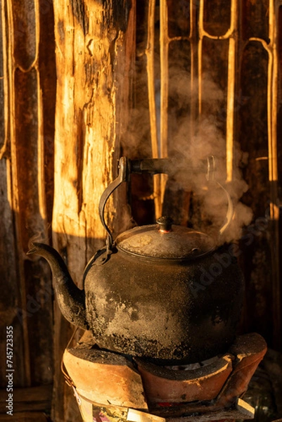 Obraz Old kettle on flaming fire with steam boiling water and nature background in morning time