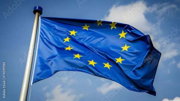 Fototapeta Waving European Union Flag Against Blue Sky Symbolizing Political Integration and Unity, EU Symbol.