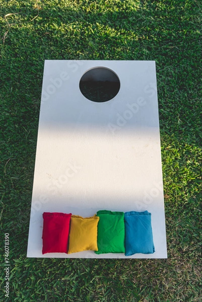 Fototapeta Cornhole (sack toss, or bags) is a lawn game popular in North America in which players or teams take turns throwing fabric bean bags at a raised, angled board with a hole in its far end
