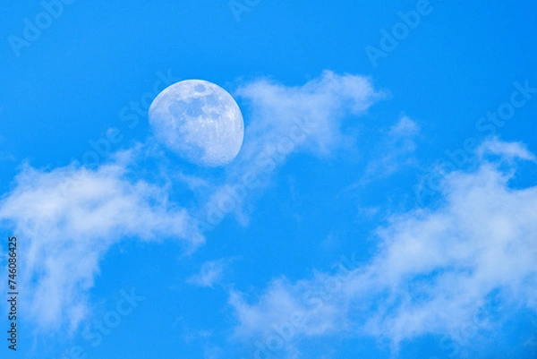Fototapeta Moon behind the clouds - sharp details on the surface.
