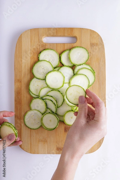 Fototapeta Cucumber sliced on a wooden chopping board and white background ingredient for recipe