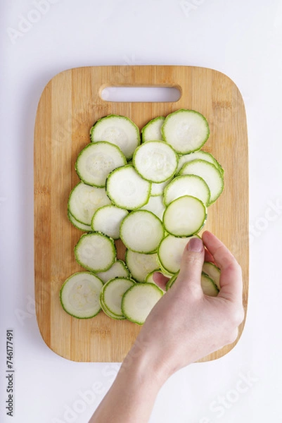 Fototapeta Cucumber sliced on a wooden chopping board and white background ingredient for recipe