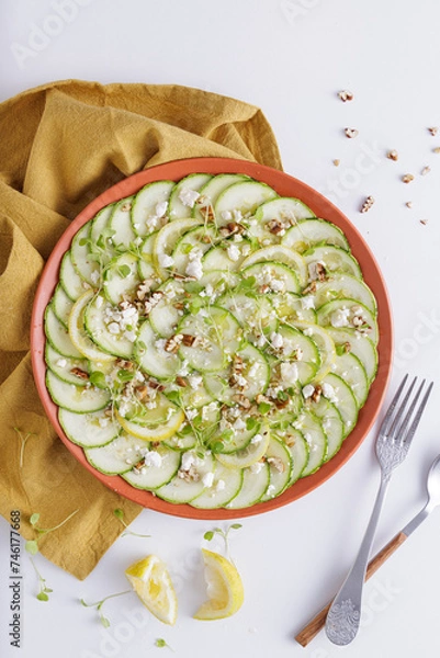 Fototapeta Cucumber Salad with White Cheese and Nuts Ingredients on a wooden chopping board and white background